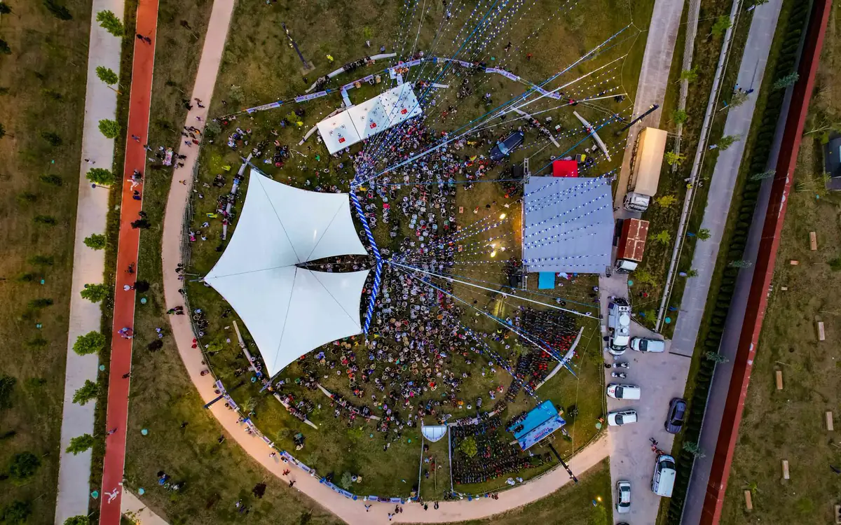 Senkrechte Drohnenaufnahme eines Open-Air-Festivals mit Zeltdach und Bühne