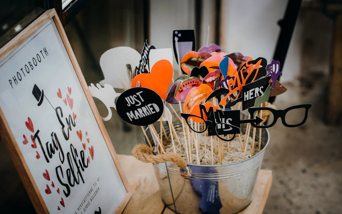 Eimer mit Fotobox-Requisiten und ein Schild mit der Aufschrift Photobooth
